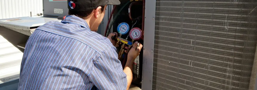 HVAC technician servicing a condenser unit in Fairfax Station