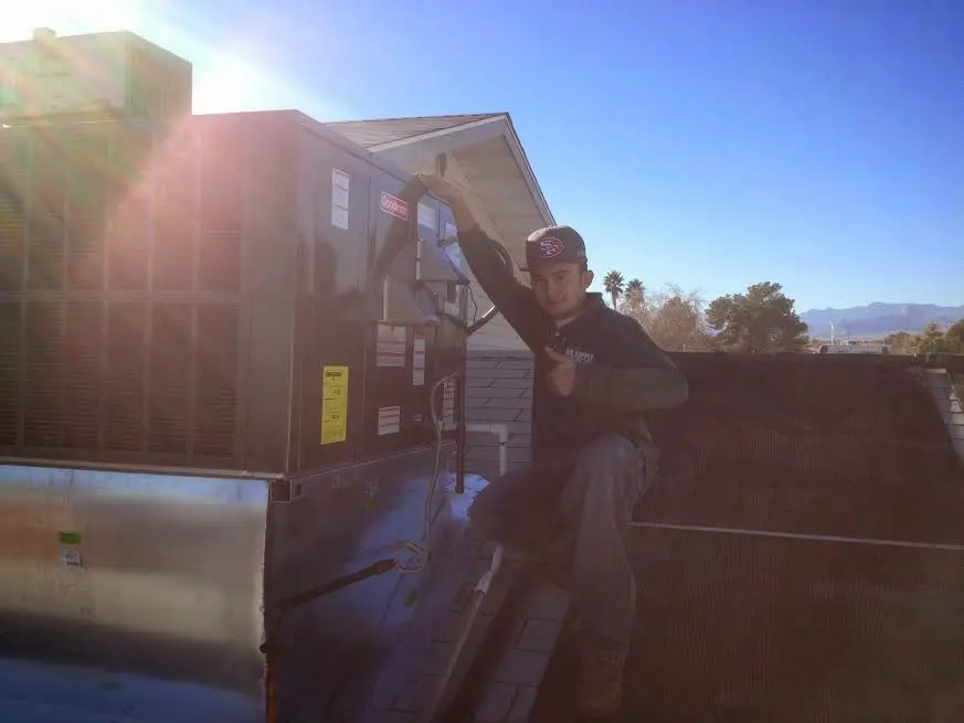HVAC technician performing AC Tune-Up on a rooftop unit in Fairfax Station